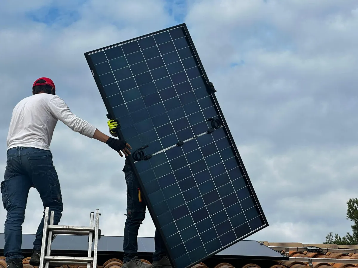 hommes avec un panneau photovoltaique sur un toit